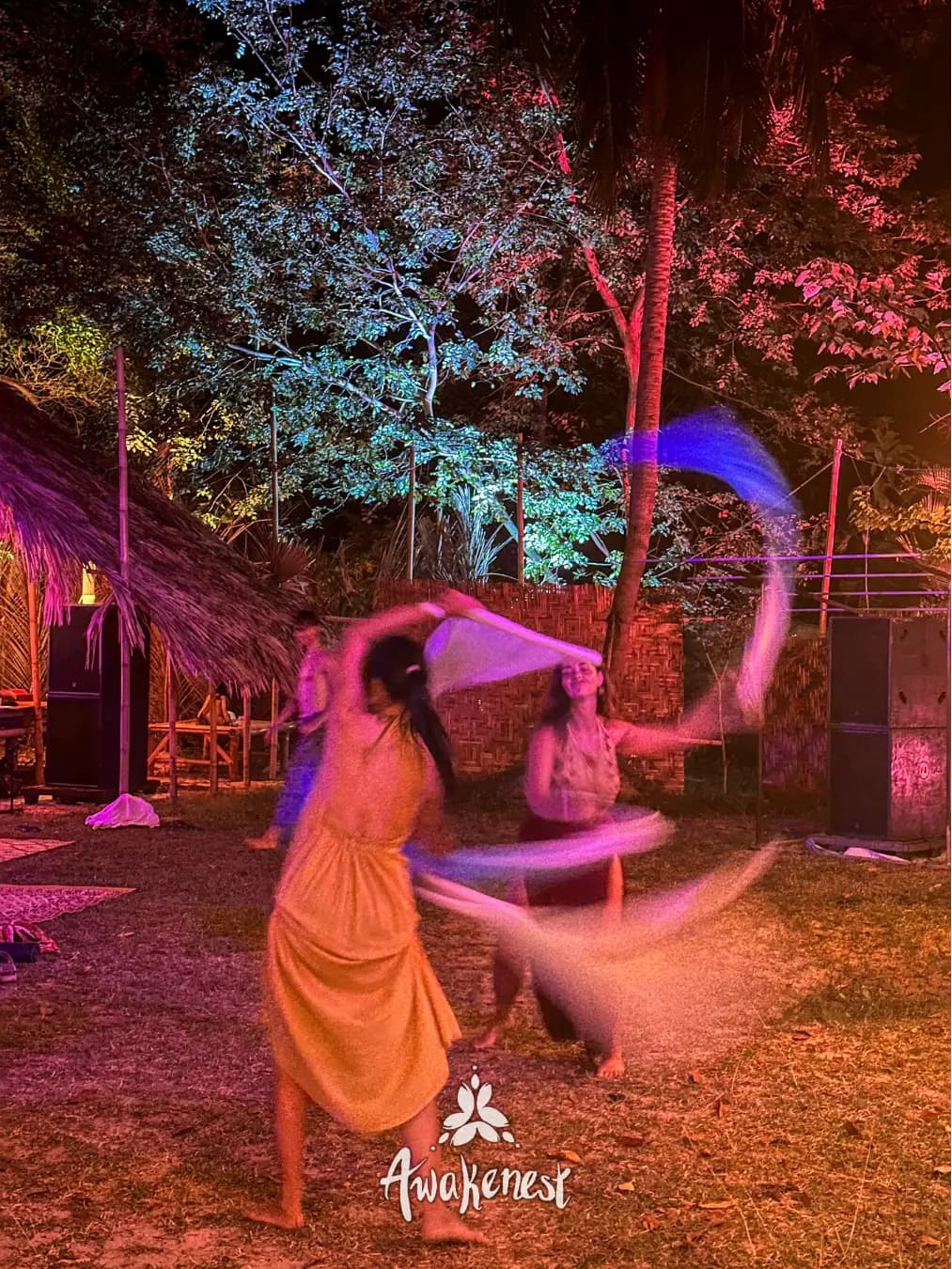 Dancer spins fabric ribbon at night event.