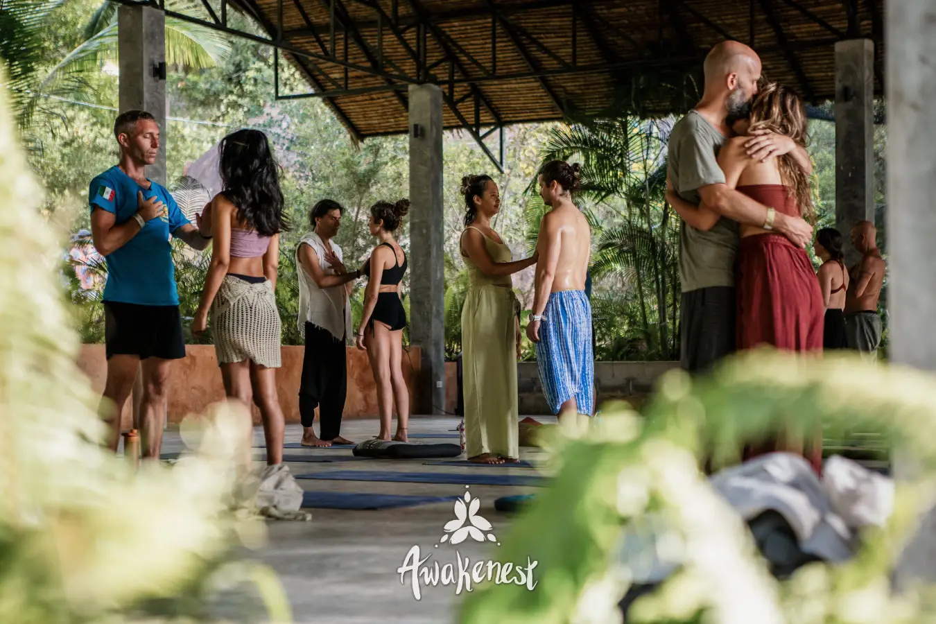 People mingle and embrace under open pavilion.