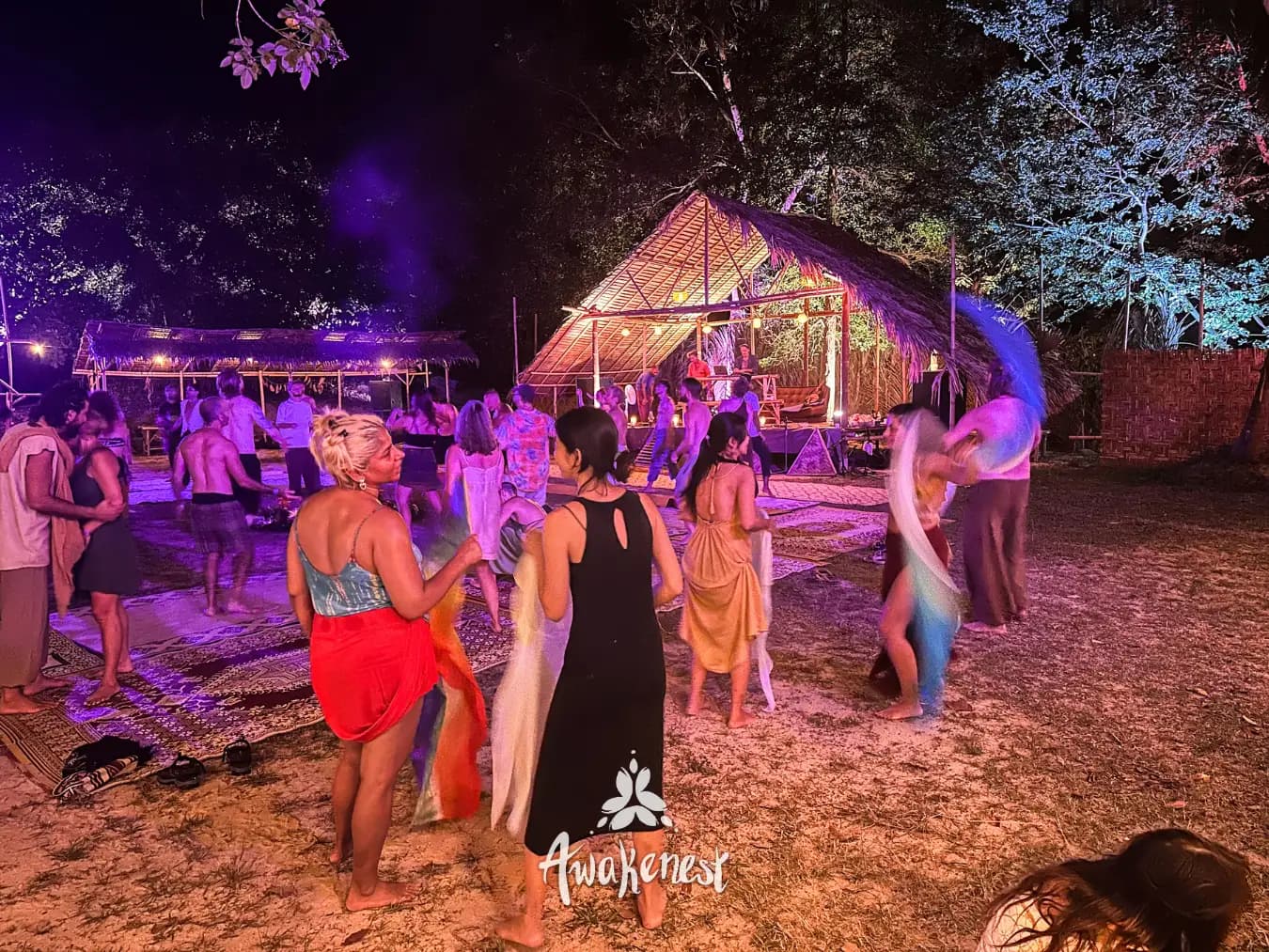 Dancers with flowing fabric under night lights.