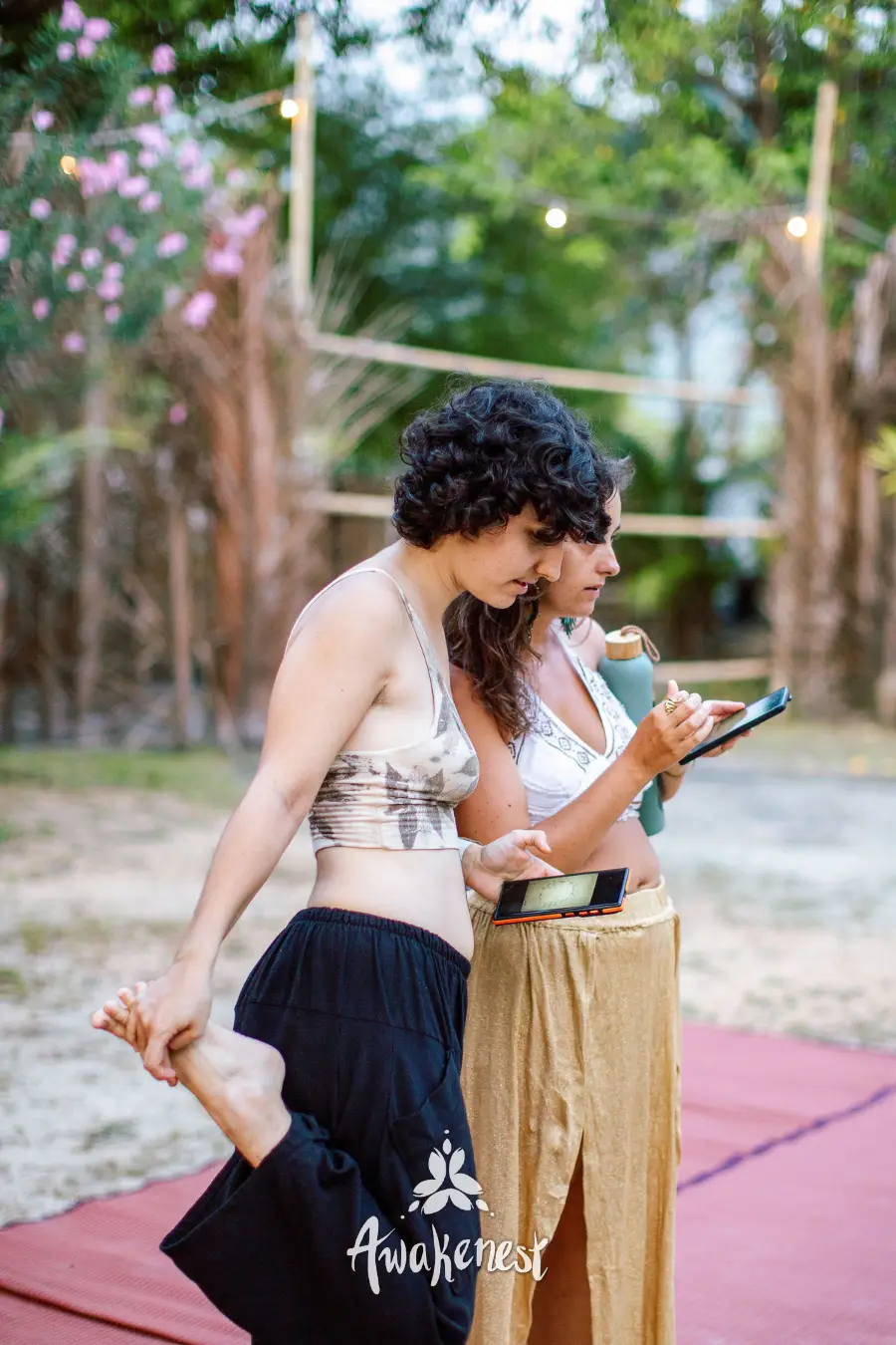Two women looking at phone outdoors.