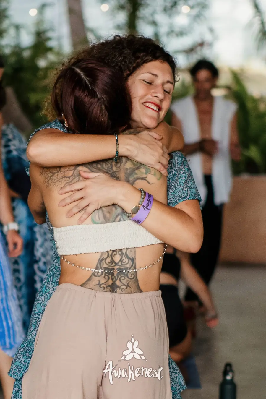 Two women embracing warmly at event.