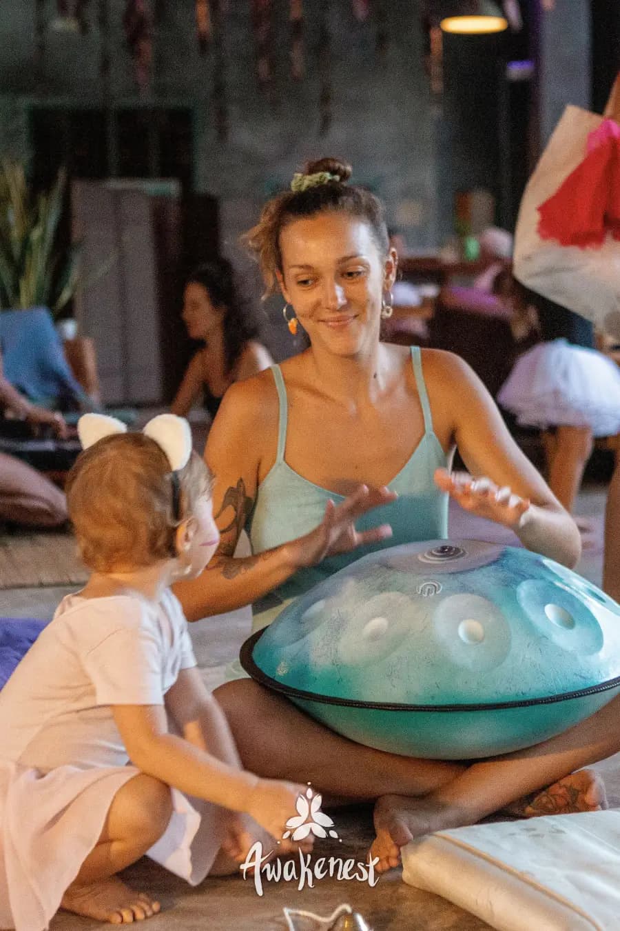 Woman and toddler playing handpan together.
