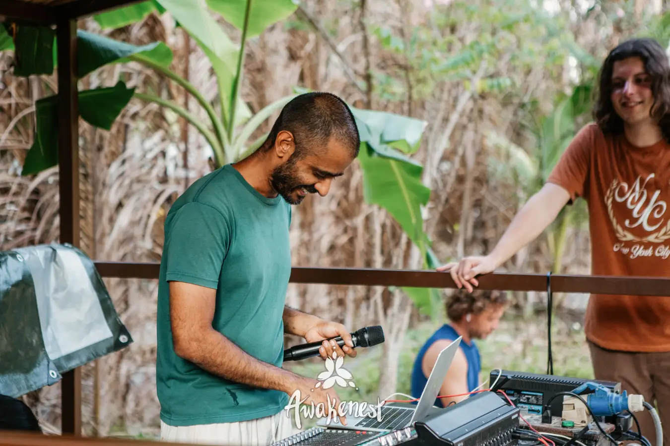 Man adjusts sound equipment at outdoor stage.