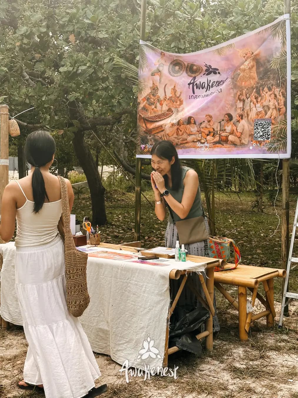 Two women at festival market stall booth.