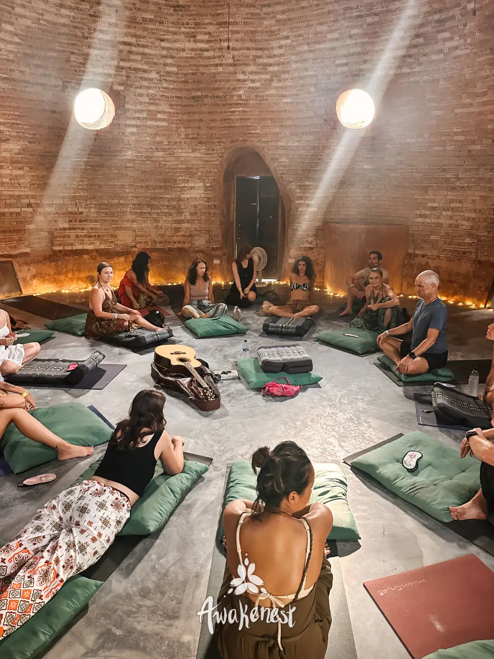 Circle gathering inside brick dome with cushions.