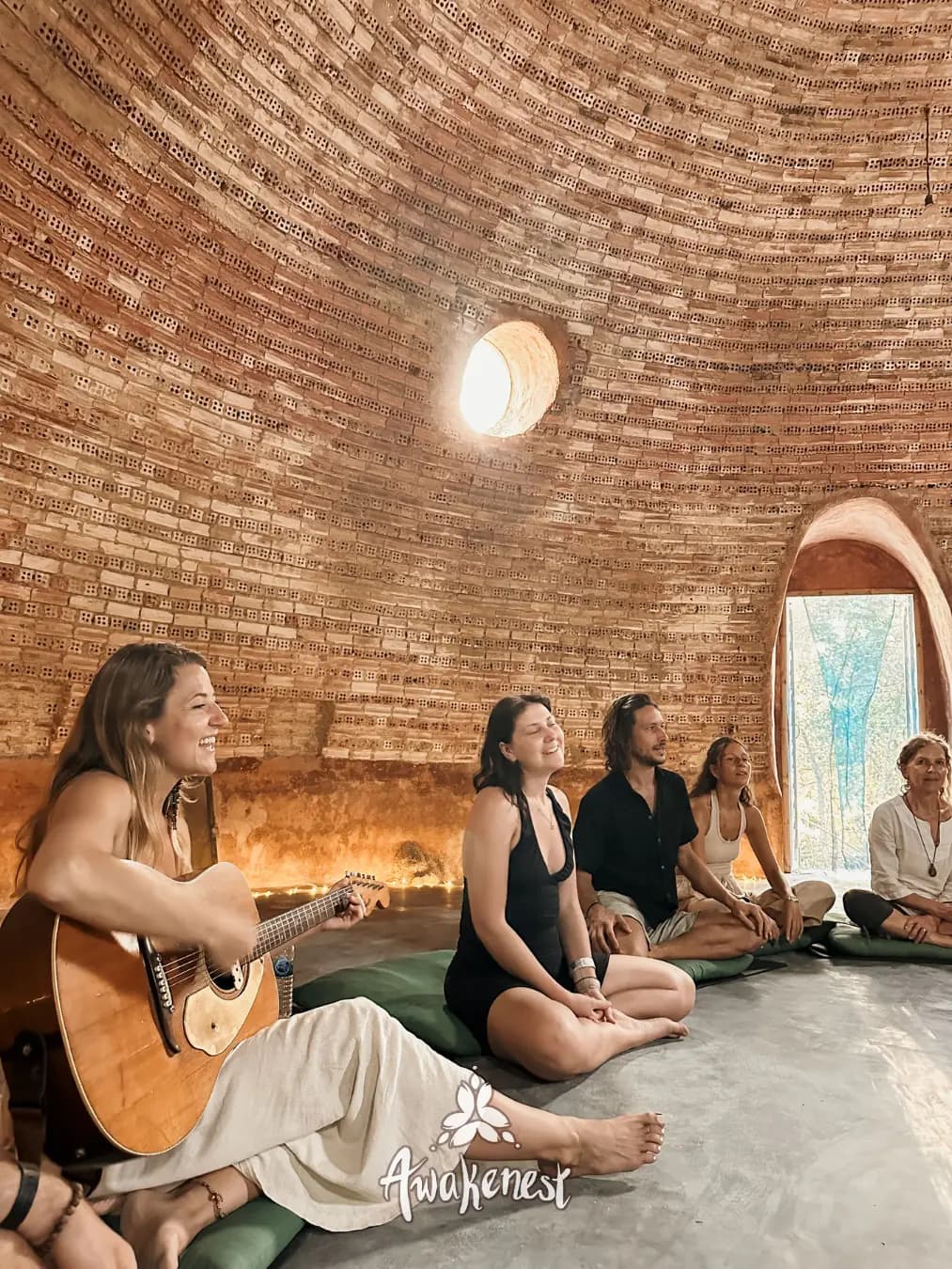 Musicians play guitar inside brick dome hall.
