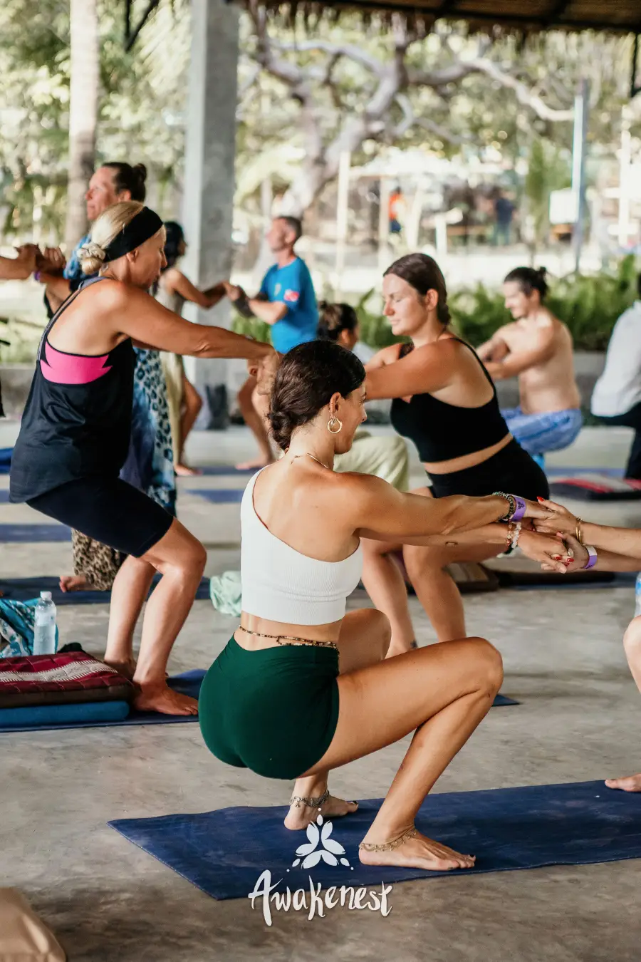 Yoga class holding chair pose together.