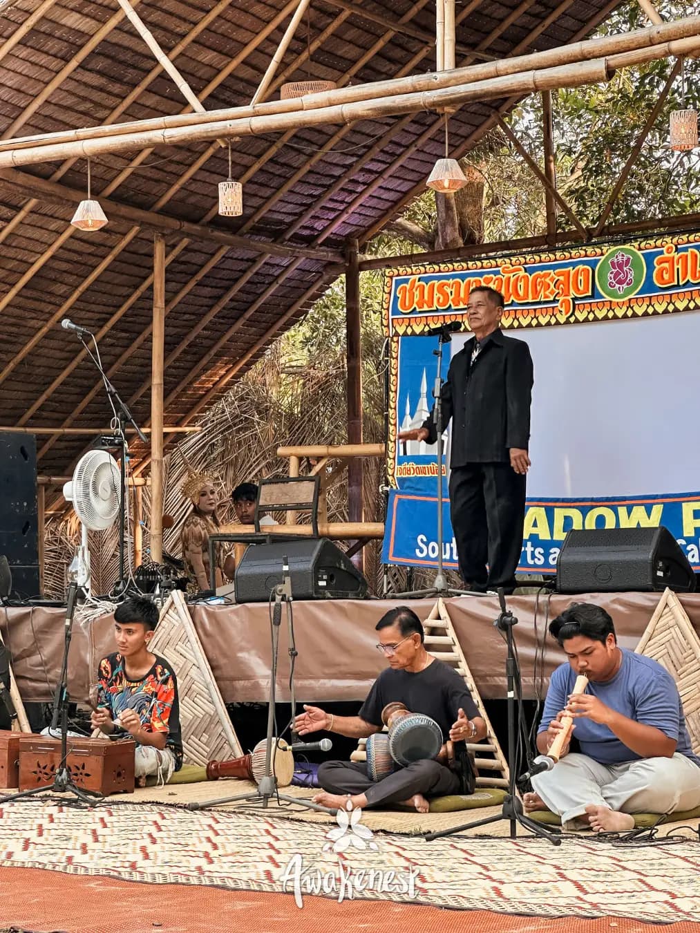 Speaker addresses crowd at shadow play show.