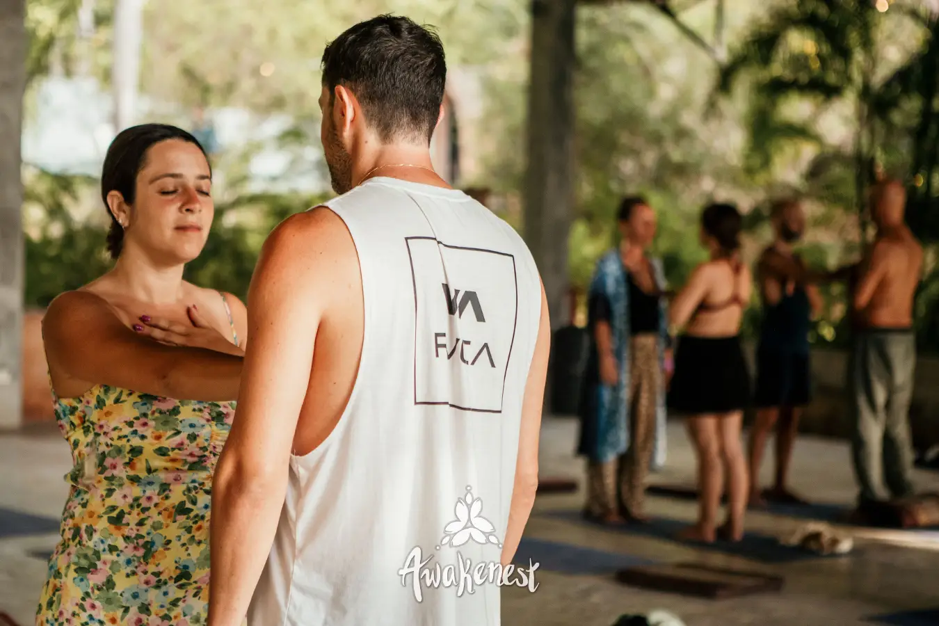 Two people embrace near yoga group session.