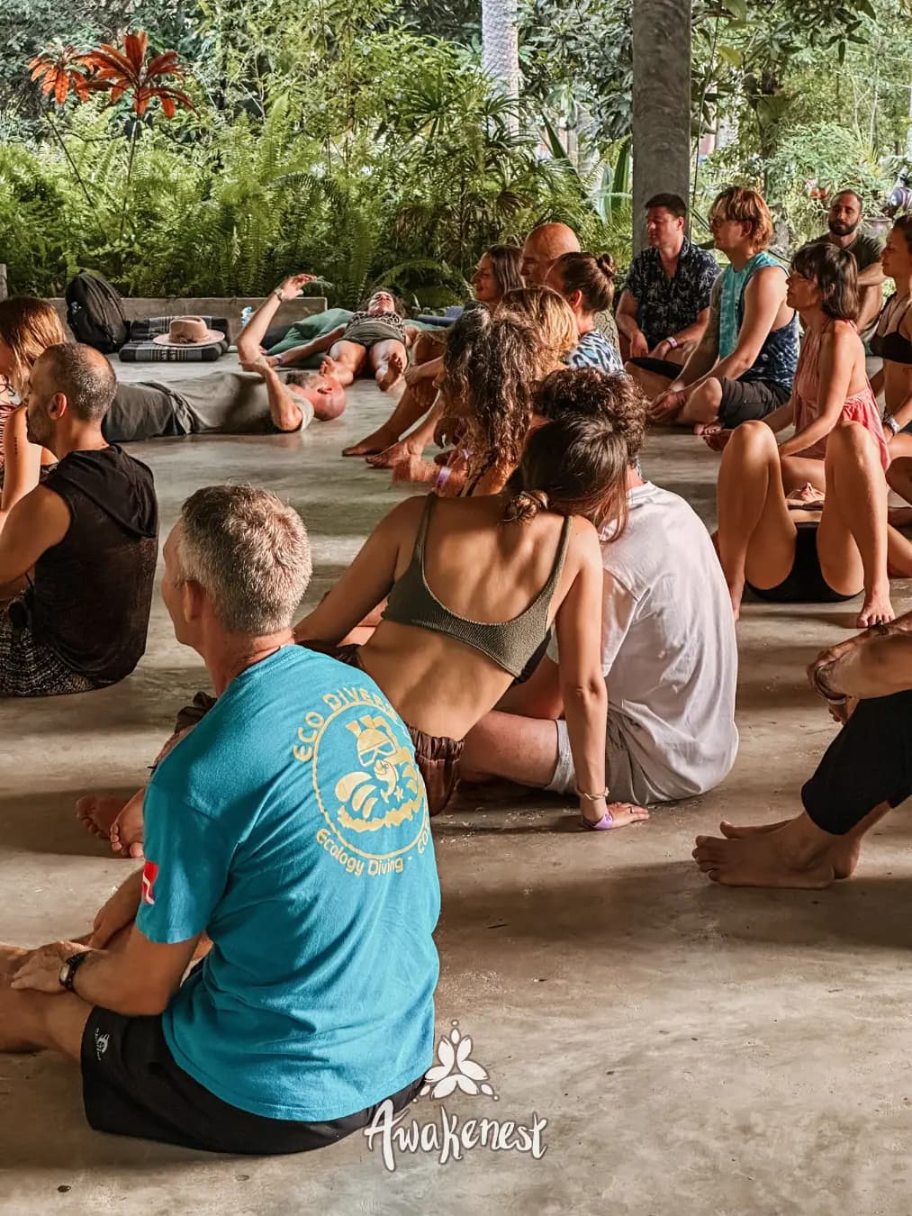 Group sitting closely in circle outdoors.