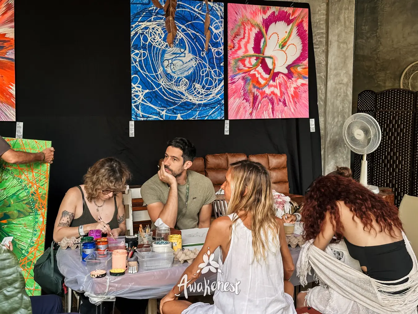 Group painting session beneath colorful artwork.
