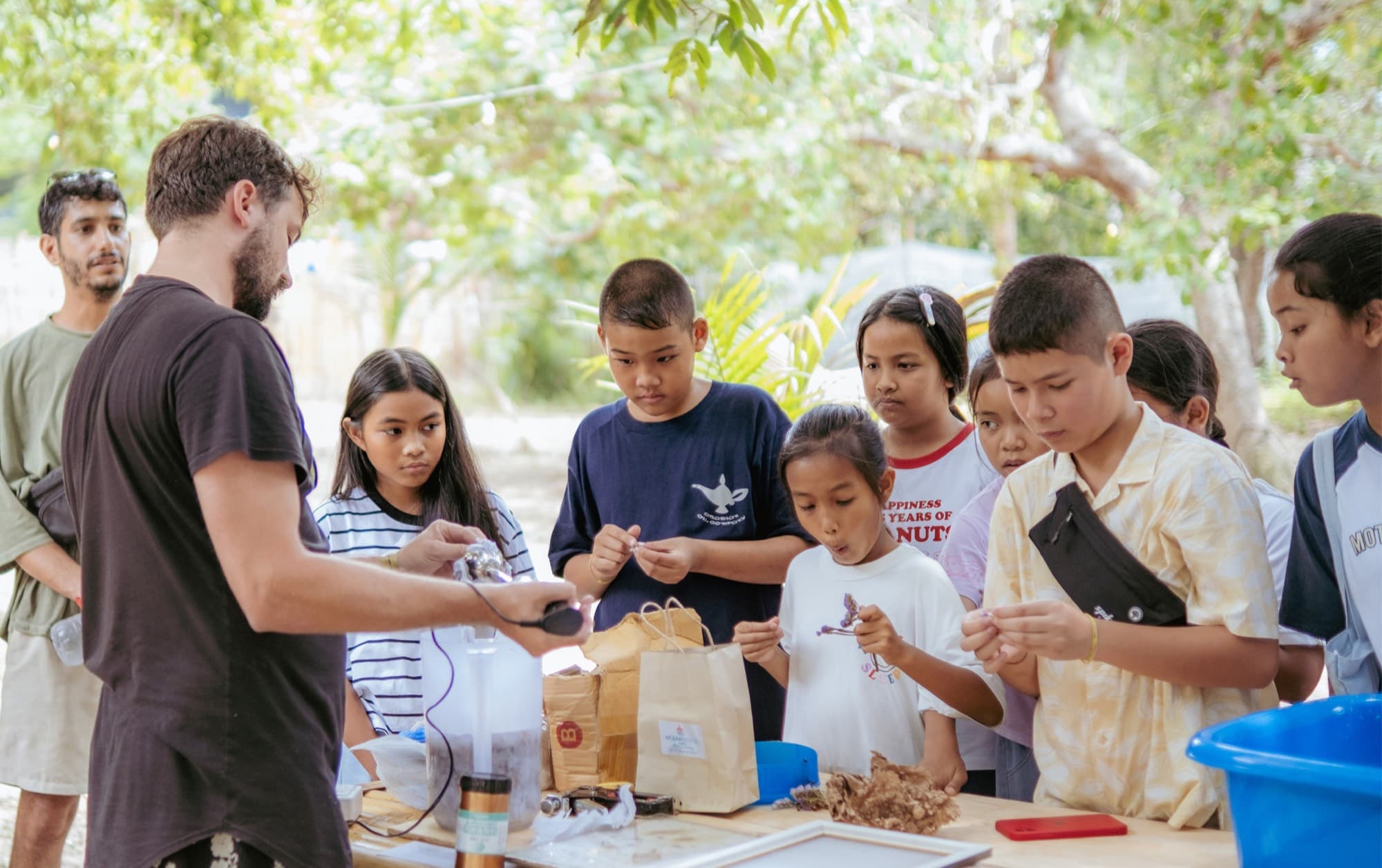 Young Awakenest visitors gathering around a collaborative activity at a festival stall
