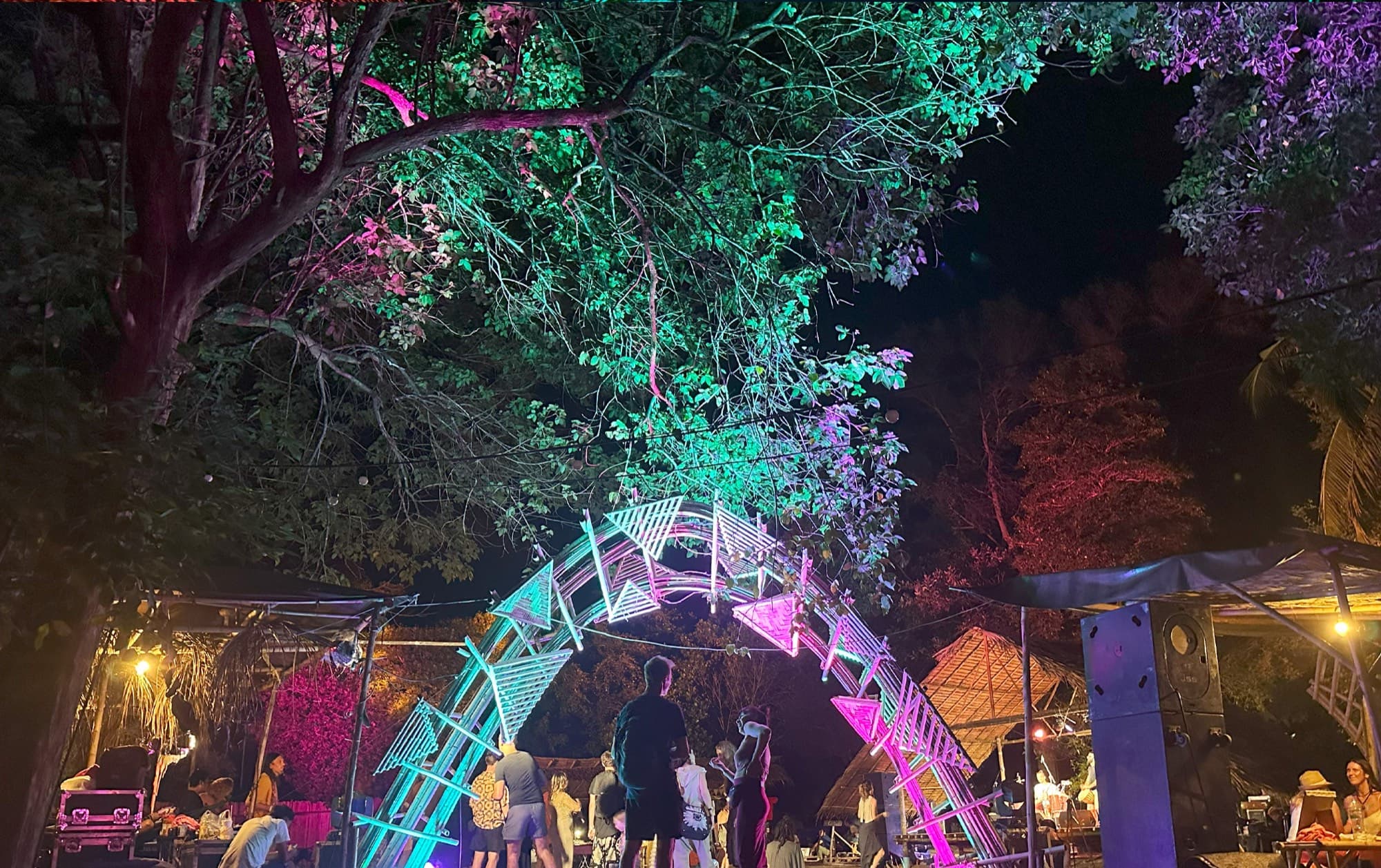 An illuminated archway on the Awakenest grounds with people passing beneath it